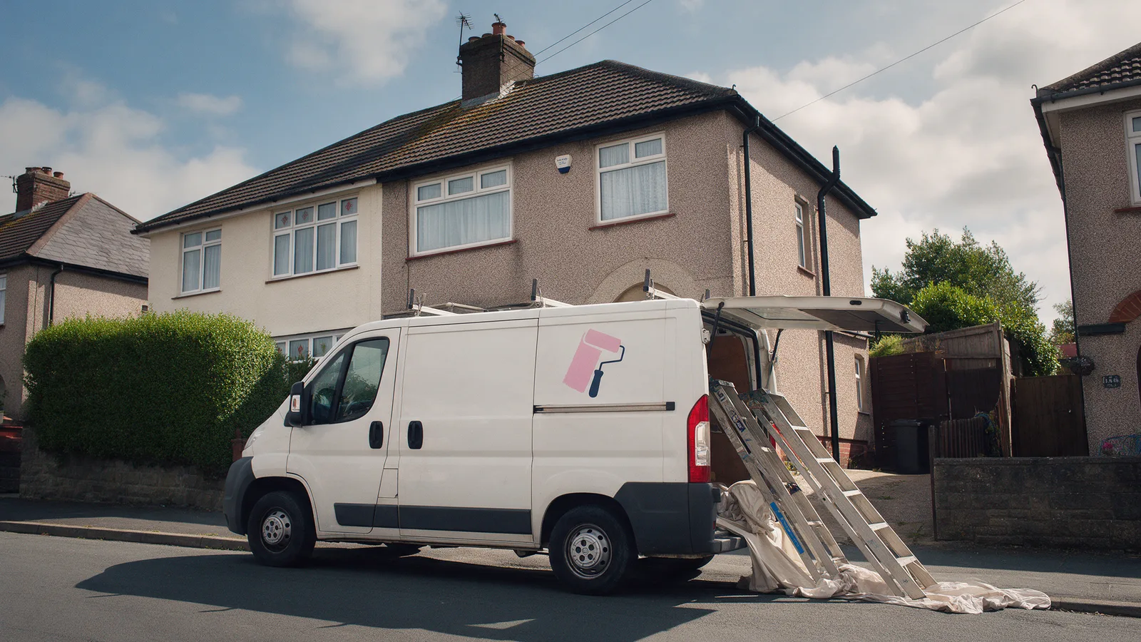 A white van with a pink and navy roller logo outside a 1930s semi in Whitchurch, stepladders and dust sheets being unloaded