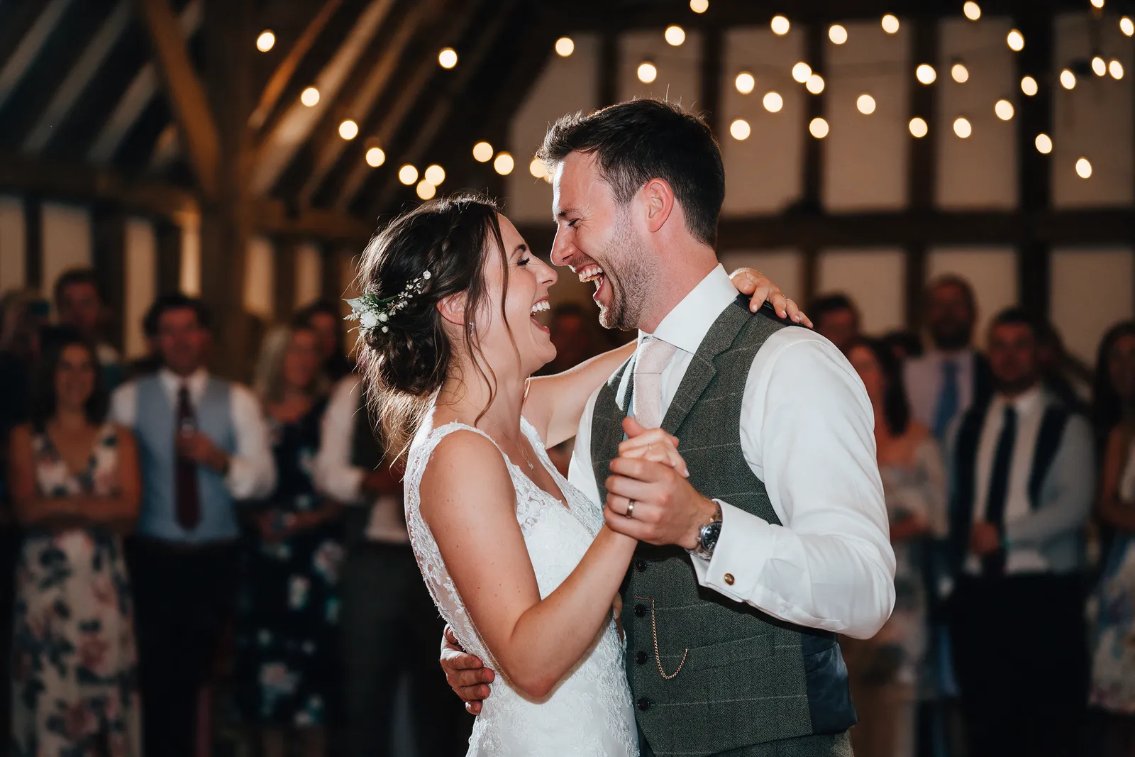 A first dance under festoon lights in a barn