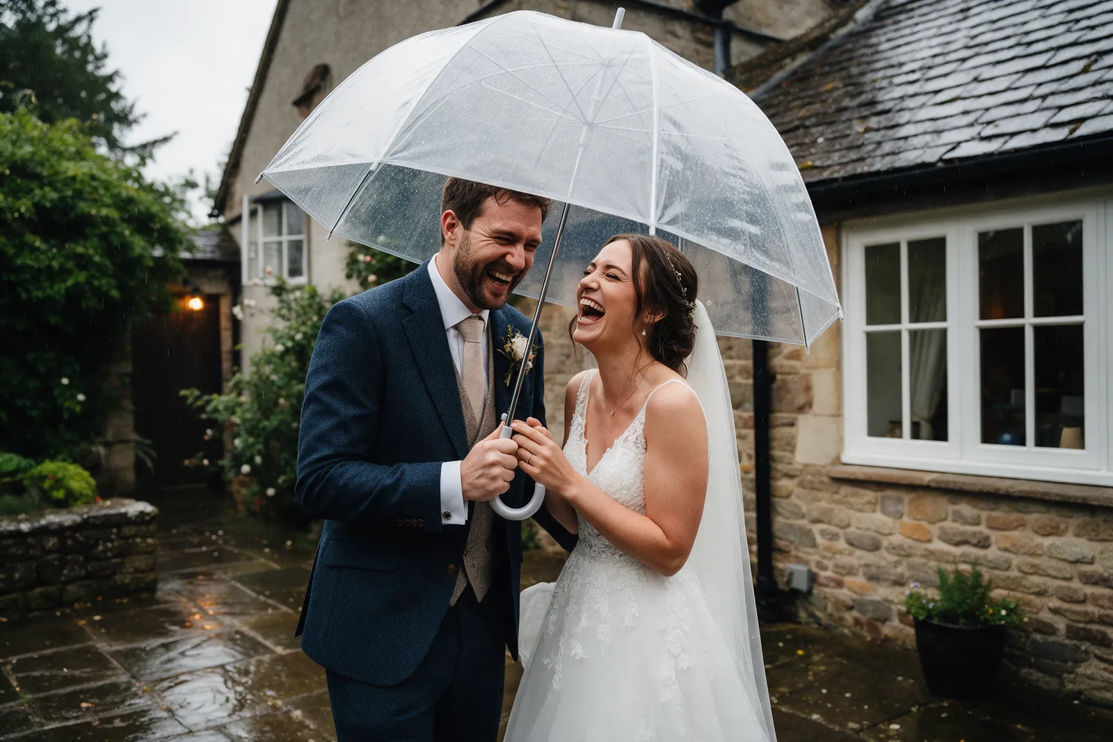 A couple sharing a clear umbrella in soft rain outside a country house