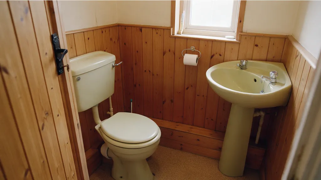 The same cloakroom before: pine tongue-and-groove panelling and a pedestal basin