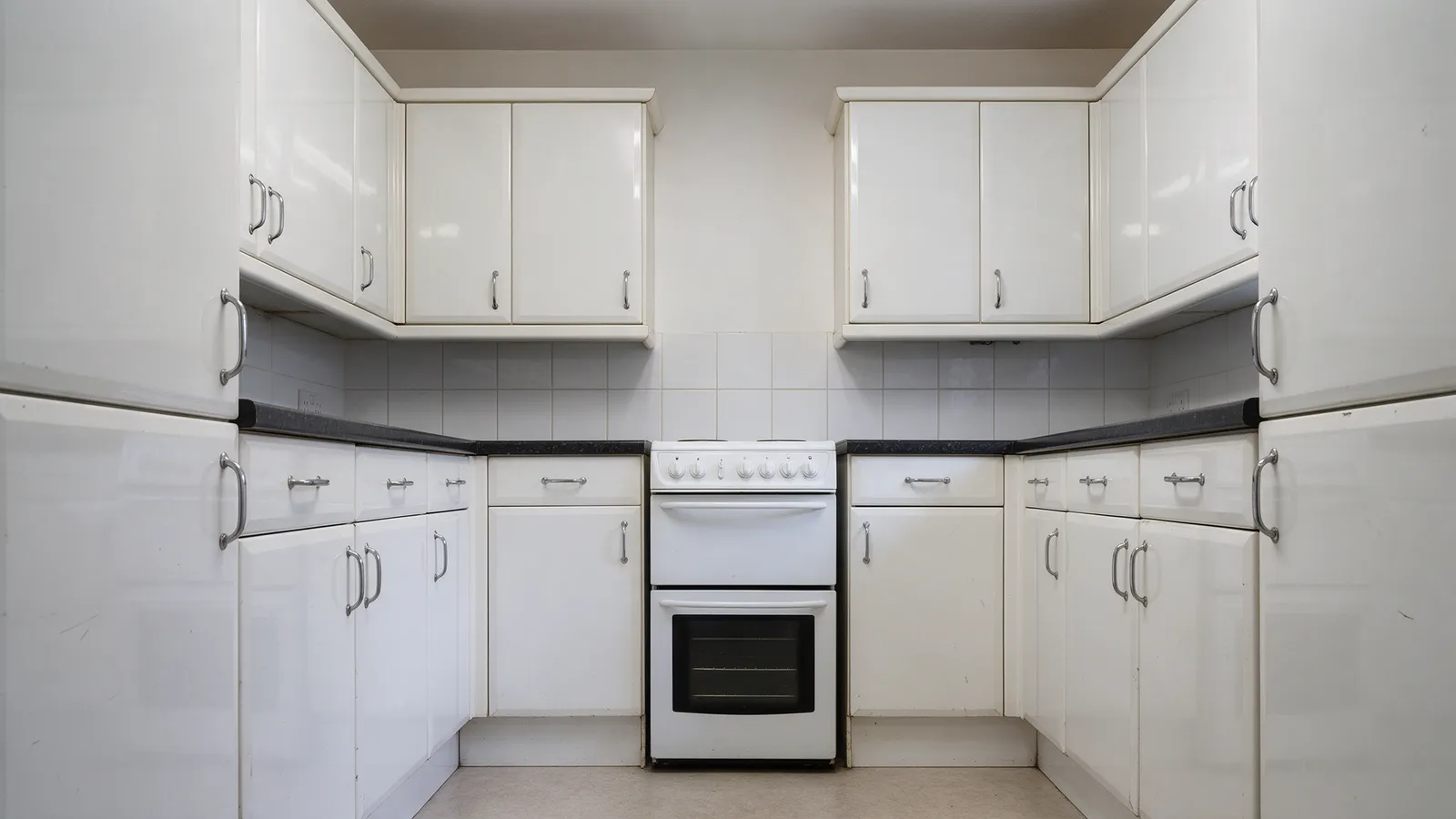 The same kitchen before: a 2005 white gloss kitchen with a freestanding cooker