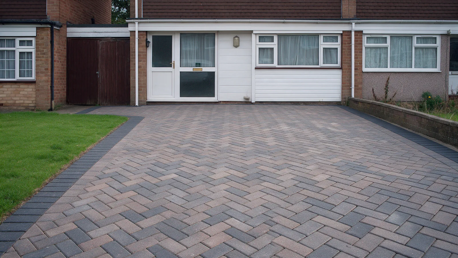 The same driveway after: brindle block paving in herringbone with a charcoal border and a clean edge