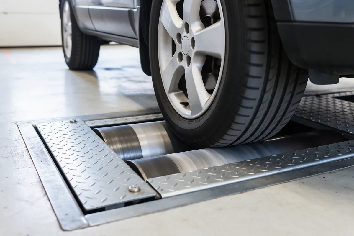 A car's front wheels on the brake roller tester